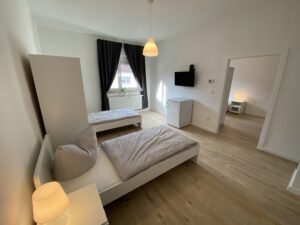 Geräumiges Monteurzimmer mit Einzelbetten, Fernseher und Kühlschrank