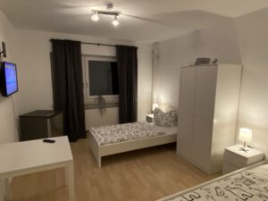 Geräumiges Monteurzimmer mit Einzelbetten, Fernseher und Kühlschrank