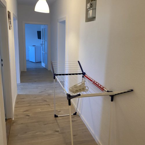 Auf dem Flur einer unserer modernen Monteurwohnungen steht ein Wäscheständer